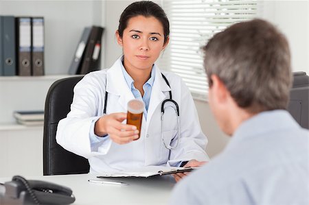 doctor with ethnic patient in office - Beautiful female doctor showing a box of pills to the camera in her office Stock Photo - Budget Royalty-Free & Subscription, Code: 400-04415846