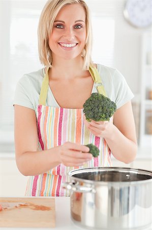 simsearch:400-05740111,k - Close up of a woman cooking broccoli looks into the camera in the kitchen Stock Photo - Budget Royalty-Free & Subscription, Code: 400-04417686