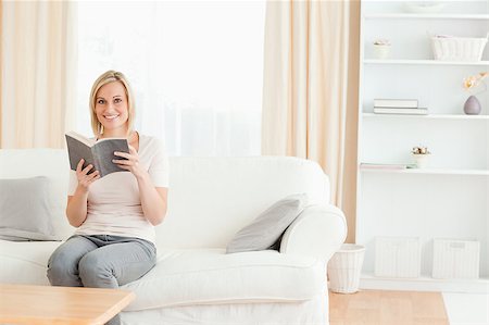 simsearch:400-04418460,k - Blond-haired woman with a book in her living room Stock Photo - Budget Royalty-Free & Subscription, Code: 400-04418460