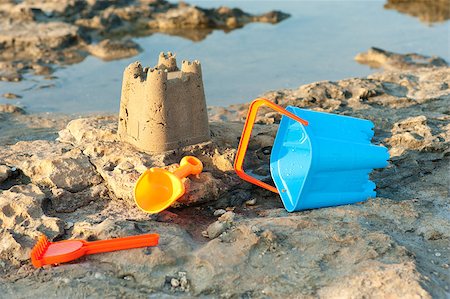 simsearch:400-04423521,k - A sand castle and toy tools in scenic setting Photographie de stock - Aubaine LD & Abonnement, Code: 400-04418860
