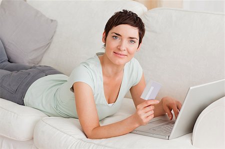simsearch:400-04410667,k - Cute woman shopping online while looking at the camera Stock Photo - Budget Royalty-Free & Subscription, Code: 400-04410658