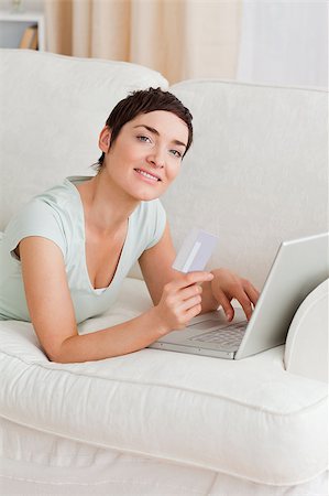 simsearch:400-04410667,k - Portrait of a cute woman shopping online while looking at the camera Stock Photo - Budget Royalty-Free & Subscription, Code: 400-04410662