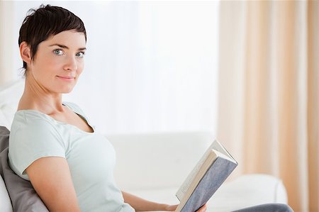 simsearch:400-04418460,k - Short-haired woman holding a book while lokking at the camera Stock Photo - Budget Royalty-Free & Subscription, Code: 400-04410673