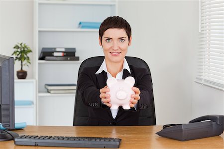 simsearch:6108-05874788,k - Office worker holding a piggybank in her office Foto de stock - Super Valor sin royalties y Suscripción, Código: 400-04410884