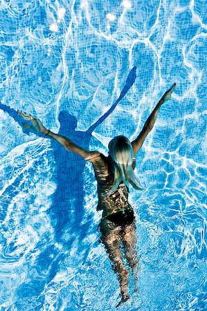 simsearch:400-04058760,k - Young active woman swimming under water in the pool during one splendid day of summer full of sun Photographie de stock - Aubaine LD & Abonnement, Code: 400-04411870