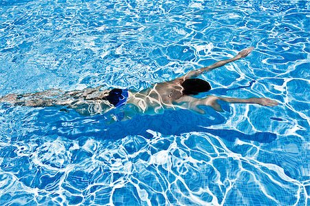 simsearch:400-04058760,k - Young man swimming under blue water in swimming pool Photographie de stock - Aubaine LD & Abonnement, Code: 400-04413152