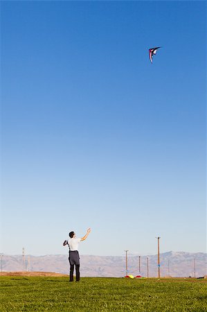 sky in kite alone pic - young man flying a kite in the park Foto de stock - Super Valor sin royalties y Suscripción, Código: 400-04422927