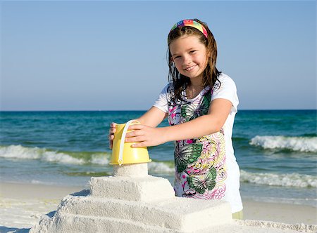 Happy girl building sandcasttle on a beach Stock Photo - Budget Royalty-Free & Subscription, Code: 400-04423521