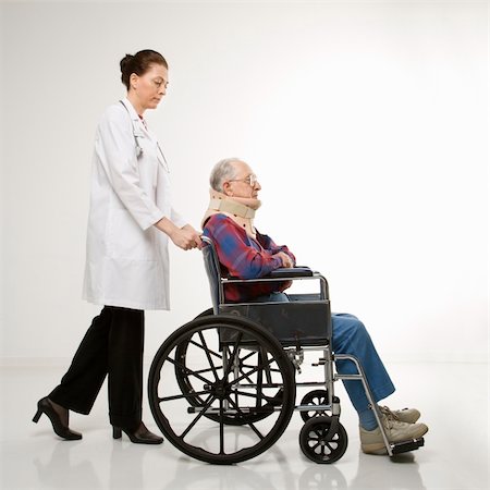 Mid-adult Caucasian female doctor pushing elderly Caucasian male with neck brace in wheelchair. Stock Photo - Budget Royalty-Free & Subscription, Code: 400-04449866