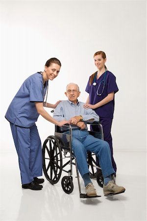 Two Caucasian females wearing scrubs with elderly Caucasian male in wheelchair. Stock Photo - Budget Royalty-Free & Subscription, Code: 400-04449873