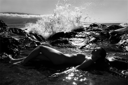 simsearch:400-04450827,k - Caucasian young adult woman lying nude in tidal pool in Maui with wave crashing in distance. Stock Photo - Budget Royalty-Free & Subscription, Code: 400-04450462
