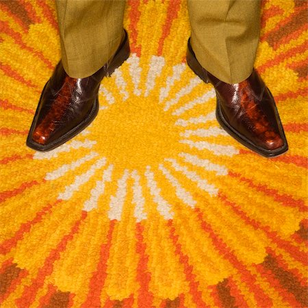 simsearch:400-04450069,k - Close-up of Caucasian mid-adult male feet in vintage boots against sunburst rug. Stock Photo - Budget Royalty-Free & Subscription, Code: 400-04451389