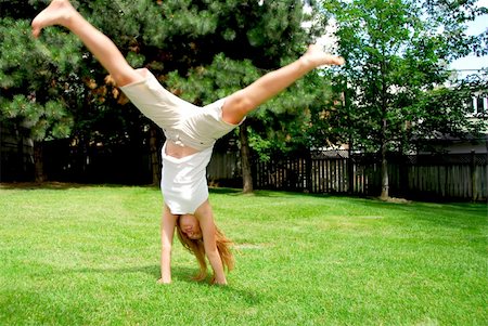 preteen girls gymnastics - Young girl doing a cartwheel on green grass Stock Photo - Budget Royalty-Free & Subscription, Code: 400-04452705