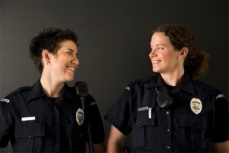 female police officer happy - Two mid adult Caucasian policewomen standing looking at each other smiling. Photographie de stock - Aubaine LD & Abonnement, Code: 400-04468906