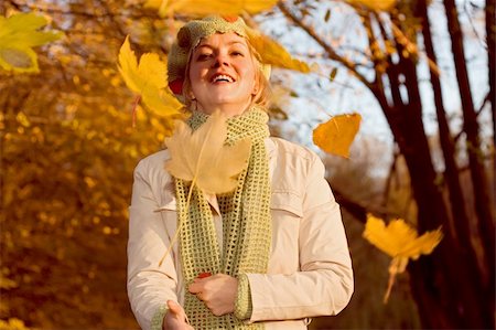 Happy woman with falling yellow leaves in the autumn park, warm afternoon lights Stock Photo - Budget Royalty-Free & Subscription, Code: 400-04470455
