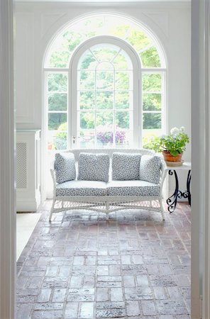 elegant room with arched windows - Brightly lit sunroom with wicker couch. Stock Photo - Budget Royalty-Free & Subscription, Code: 400-04471520