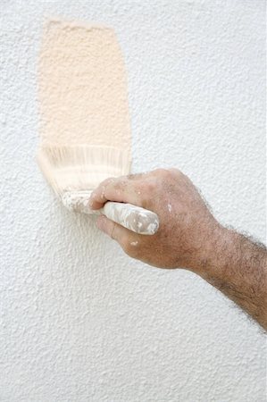 A man's paint-spattered hand holding a paintbrush and painting a house. Stock Photo - Budget Royalty-Free & Subscription, Code: 400-04485419