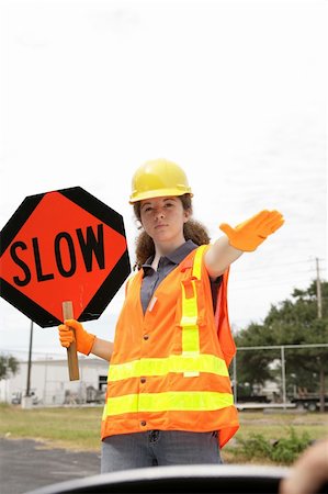 A road crew member holding a sign & telling a driver to slow down. Room for text Stock Photo - Budget Royalty-Free & Subscription, Code: 400-04485432