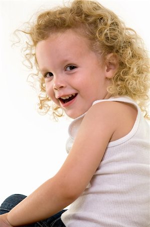 Portrait of an adorable little three year old boy wearing white top sitting on a chair with a curly long blond hair with a cute smile Stock Photo - Budget Royalty-Free & Subscription, Code: 400-04499369