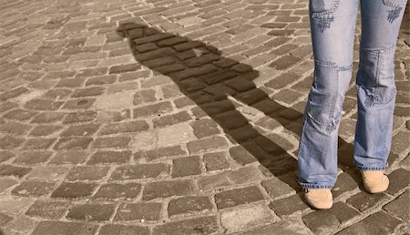 Legs in jeans casting a shadow on a pavement street. Special color management. Photographie de stock - Aubaine LD & Abonnement, Code: 400-04492968