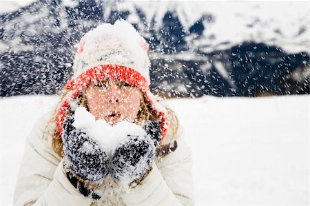 winter scene: girl blowing snow away. The focus is on the gloves. Stock Photo - Budget Royalty-Free & Subscription, Code: 400-04493460