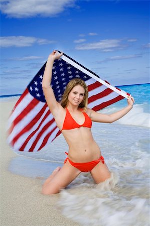 Beautiful Caucasian female teenage kneeling on the beach and holding an United States Flag while wearing a red bikini. Stock Photo - Budget Royalty-Free & Subscription, Code: 400-04505661