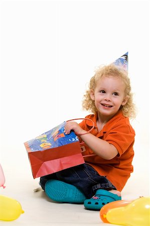 simsearch:400-04847852,k - Adorable little three year old boy wearing party hat sitting with balloons with hand in a gift bag Stock Photo - Budget Royalty-Free & Subscription, Code: 400-04500094
