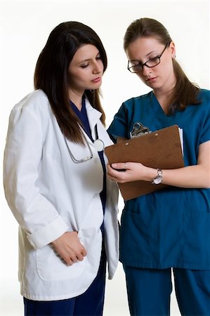 simsearch:400-07411030,k - Two woman healthcare workers one wearing a doctors lab coat holding a chart the other in scrubs standing on white Stock Photo - Budget Royalty-Free & Subscription, Code: 400-04503244