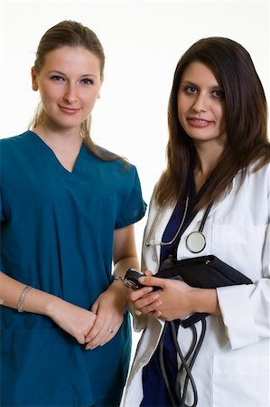 simsearch:400-07411030,k - Two woman healthcare workers one wearing a doctors lab coat holding a chart the other in scrubs standing on white Stock Photo - Budget Royalty-Free & Subscription, Code: 400-04503246