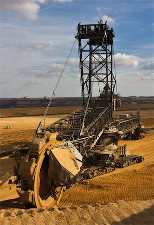 Giant bucket wheel excavator taking away the layers of ground before digging the brown coal. Stock Photo - Budget Royalty-Free & Subscription, Code: 400-04527268