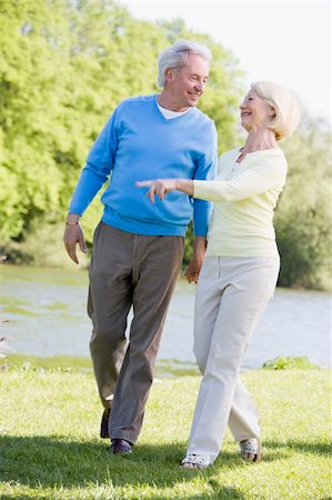 simsearch:400-04035087,k - Couple walking outdoors at park by lake smiling Stock Photo - Budget Royalty-Free & Subscription, Code: 400-04528794