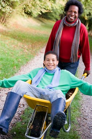simsearch:400-04035087,k - Mother pushing teenage son laying in wheelbarrow Stock Photo - Budget Royalty-Free & Subscription, Code: 400-04535473