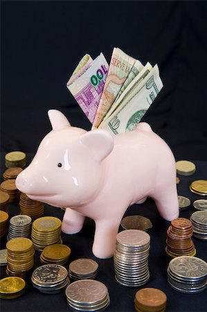simsearch:400-06077471,k - Piggybank with various international currencies on a black background. Stock Photo - Budget Royalty-Free & Subscription, Code: 400-04547841