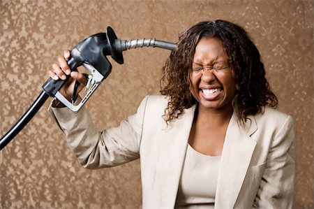 Woman holding gas nozzle like a gun to her head Stock Photo - Budget Royalty-Free & Subscription, Code: 400-04540567