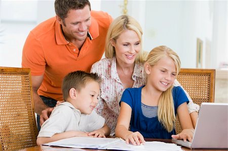 simsearch:400-05751173,k - Couple helping two young children with laptop do homework in din Stock Photo - Budget Royalty-Free & Subscription, Code: 400-04540595