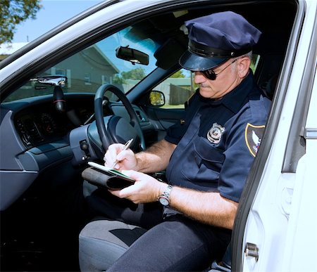 Police officer in his squad car, filling out a citation. Stock Photo - Budget Royalty-Free & Subscription, Code: 400-04559279