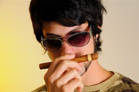 simsearch:400-05207678,k - Portrait of trendy latino man smelling cigar over yellow background Stock Photo - Budget Royalty-Free & Subscription, Code: 400-04551332
