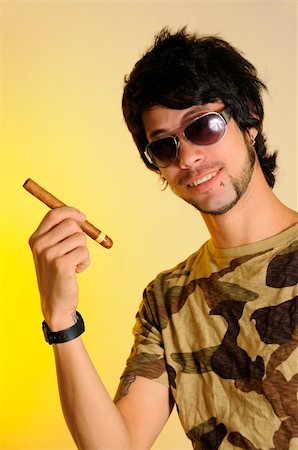 simsearch:400-05207678,k - Portrait of trendy latino man holding cigar over yellow background Stock Photo - Budget Royalty-Free & Subscription, Code: 400-04551333