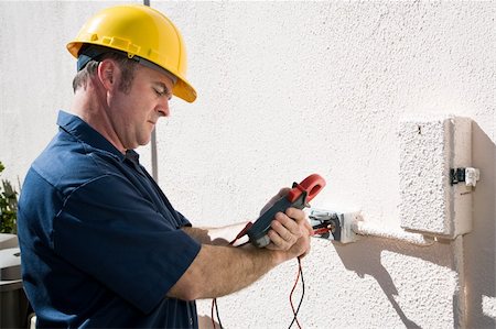 Electrician using a meter to check the voltage on an outdoor receptacle.  Model is a licensed master electrican and all work is performed according to  industry code and safety standards. Stock Photo - Budget Royalty-Free & Subscription, Code: 400-04565106