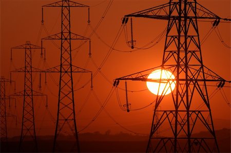 Setting Sun seen through a row of electricity pylons Stock Photo - Budget Royalty-Free & Subscription, Code: 400-04568383
