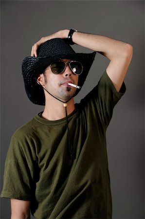 simsearch:400-04163139,k - Portrait of young male smoking with sunglasses and cowboy hat Stock Photo - Budget Royalty-Free & Subscription, Code: 400-04574560