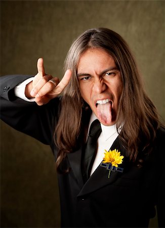 simsearch:400-04831298,k - Handsome man with tongue out making bull horns gesture in formal jacket and boutonniere Stock Photo - Budget Royalty-Free & Subscription, Code: 400-04596344