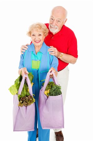 Senior couple bringing home organic produce in reusable cloth grocery bags.  Isolated on white. Photographie de stock - Aubaine LD & Abonnement, Code: 400-04606976