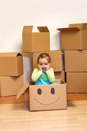 Little girl in cardboard box with a smiley - moving concept Foto de stock - Super Valor sin royalties y Suscripción, Código: 400-04602303