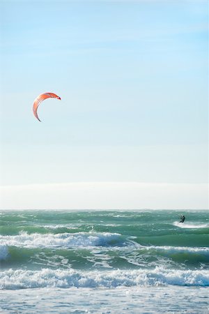 simsearch:400-03992760,k - Surfer with red kite surfing off the beach in San Francisco, California on a sunny day. Stock Photo - Budget Royalty-Free & Subscription, Code: 400-04603020