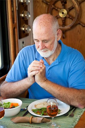 Handsome senior man saying grace over a meal in his motor home. Stock Photo - Budget Royalty-Free & Subscription, Code: 400-04618005