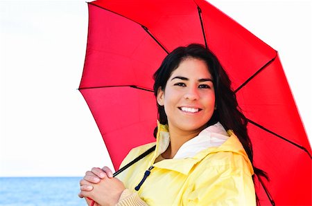 red mohawk - Portrait of beautiful smiling brunette girl wearing yellow raincoat holding red umbrella Photographie de stock - Aubaine LD & Abonnement, Code: 400-04619871