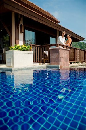 A young attractive couple standing by their pool villa with drinks Stock Photo - Budget Royalty-Free & Subscription, Code: 400-04611290