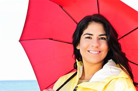 red mohawk - Portrait of beautiful smiling brunette girl wearing yellow raincoat holding red umbrella Photographie de stock - Aubaine LD & Abonnement, Code: 400-04622261