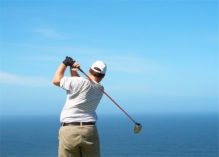 Young male golfer hitting the ball from the tee box next to the ocean on a beautiful summer day Stock Photo - Budget Royalty-Free & Subscription, Code: 400-04622372